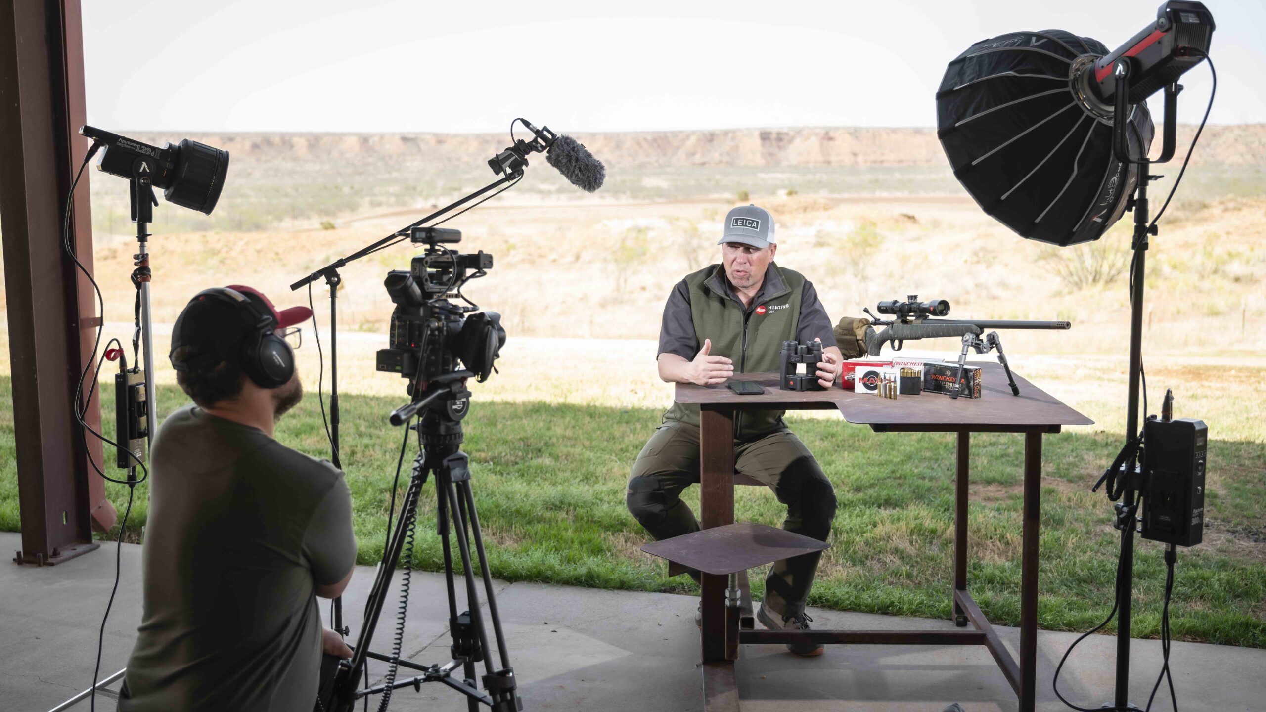 Man sitting in front of a camera and talking about his rifle.